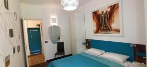 a bedroom with a blue bed and a mirror at Residence Pineda A 6 in Bibione