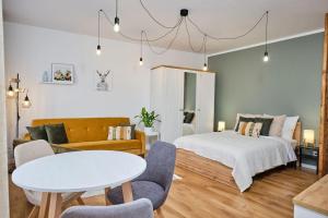a bedroom with a bed and a table and chairs at Jak w domu in Opole