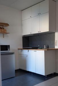 eine Küche mit weißen Schränken und einer Arbeitsplatte in der Unterkunft A Namur même, rez avec terrasse in Namur