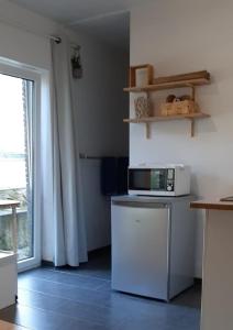 eine Küche mit einer Mikrowelle auf dem Kühlschrank in der Unterkunft A Namur même, rez avec terrasse in Namur