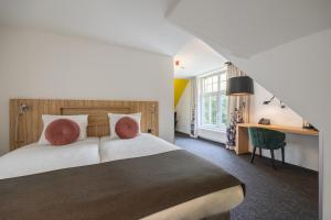 a hotel room with a bed and a desk at Amrâth Berghotel Amersfoort, BW Signature Collection in Amersfoort