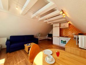 a living room with a blue couch and a table at Boddenhus Apartment in Gager