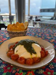 a plate of food on a table with a bowl of chips at Pousada PARAÍSO 26 in Imbituba