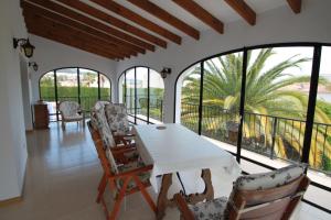 comedor con mesa, sillas y ventanas en Sara - sea view villa with private pool in Calpe, en Calpe