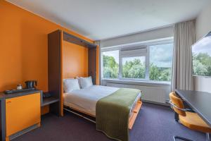 um quarto de hotel com uma cama e uma janela em Amrâth Airport Hotel Rotterdam, BW Signature Collection em Roterdão