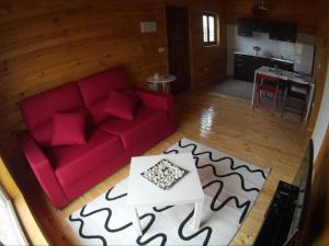 a living room with a red couch and a table at Villas Eldorado-Mascotas Bienvenidas in Barreiros