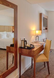 una scrivania in una camera d'albergo con letto e specchio di Hotel Premium Porto Downtown a Porto