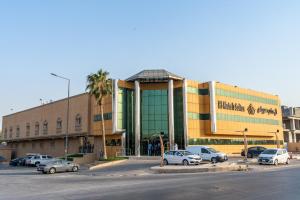 a large building with cars parked in a parking lot at ال متعب سويتس خريص in Riyadh