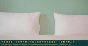 two white pillows sitting on top of a bed at Ruixiong Hotspring Hotel in Ruisui