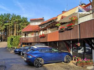 a row of cars parked in front of a building at Mini Kotedžas Vakaris in Nida