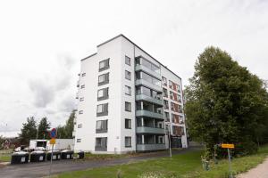 ein weißes Apartmenthaus an der Straßenseite in der Unterkunft Hiisi Homes Riihimäki in Riihimäki