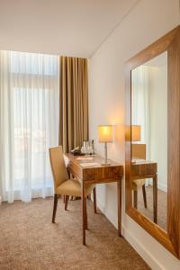 una camera d'albergo con scrivania e specchio di Hotel Premium Porto Downtown a Porto