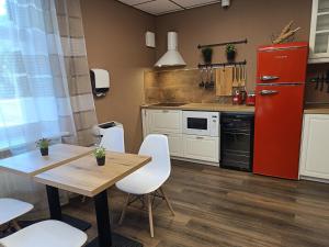 eine Küche mit einem roten Kühlschrank sowie einem Tisch und Stühlen in der Unterkunft ApartHOTELL in Narva