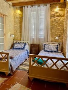 sypialnia z dwoma łóżkami i oknem w obiekcie Les Paroules - Luxury Dordogne - Holiday Farmhouses. w mieście Saint-Cybranet