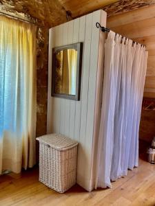 Zimmer mit weißen Vorhängen und Korbmülldose in der Unterkunft Les Paroules - Luxury Dordogne - Holiday Farmhouses. in Saint-Cybranet