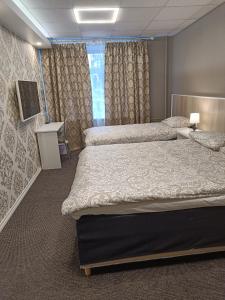 pokój hotelowy z 2 łóżkami i telewizorem w obiekcie APARTHOTEL w mieście Narwa