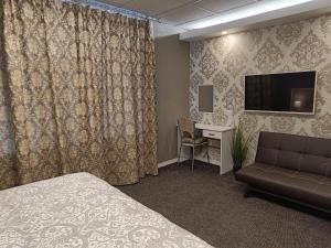 Pokój hotelowy z łóżkiem, kanapą i biurkiem w obiekcie APARTHOTEL w mieście Narwa