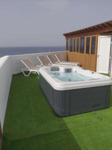 a hot tub on a patio with green grass at Santa Rosa La Peñita (Puerto del Carmen) in Puerto del Carmen