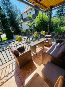a patio with wicker furniture and a table and chairs at Apartament Władek in Biały Dunajec