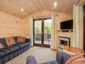 ein Wohnzimmer mit einem Sofa und einem Kamin in der Unterkunft Canadian Cabin 37 in Keswick