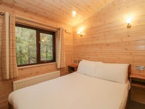 ein Schlafzimmer mit einem Bett in einer Holzhütte in der Unterkunft Canadian Cabin 37 in Keswick
