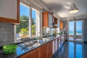 a kitchen with a sink and a large window at Villa Loureiro Palace With Soccer Field in São Gonçalo