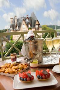 a table with plates of food and glasses of wine at La Closerie SPA & Résidence Hôtel in Deauville