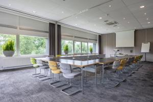 a conference room with a long table and chairs at Amrâth Airport Hotel Rotterdam, BW Signature Collection in Rotterdam