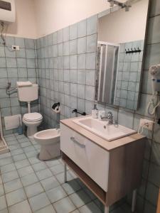 bagno con lavandino, servizi igienici e specchio di Casa Miriam a Mondragone