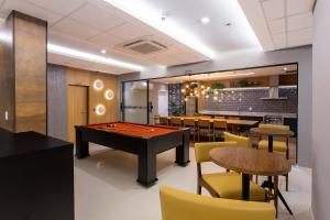 a billiard room with a pool table and chairs at Blend SmartStyle by Marzani Host in Goiânia