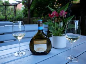 Una botella de vino y dos copas en una mesa. en Bocksbeutelherberge, en Sommerach