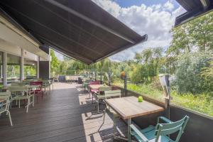 a patio with tables and chairs on a deck at Amrâth Airport Hotel Rotterdam, BW Signature Collection in Rotterdam