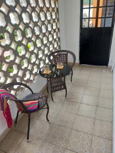 a room with two chairs and a table and a wall at Beautiful spacious room in Nairobi