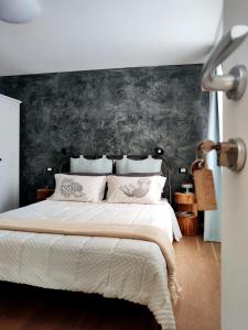 - une chambre avec un grand lit et un mur noir dans l'établissement Stanza Allegra Soave, à Soave