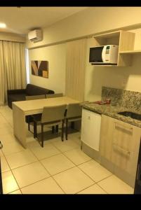 eine Küche und ein Wohnzimmer mit einem Tisch und einem Sofa in der Unterkunft BARRETOS COUNTRY in Barretos