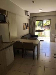 a kitchen and living room with a table and chairs at BARRETOS COUNTRY in Barretos +2 photos