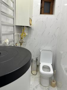 a white bathroom with a toilet and a sink at Katej in Quba