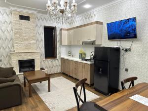 uma cozinha e sala de estar com um frigorífico preto em Katej em Quba