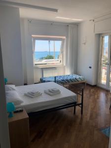 a bedroom with two beds and a large window at Blue Sea Salerno in Salerno