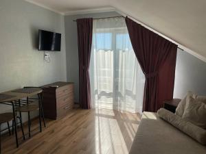 a living room with a couch and a table and a window at Yellow apartments in Boryspil