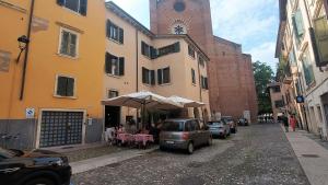 a street with a table and an umbrella in front of a building at Sottoriva Studio in Verona