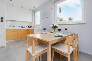 a kitchen with a wooden table with two glasses of wine at Trzy Żagle - City View Apartments with Balcony by Renters in Gdańsk