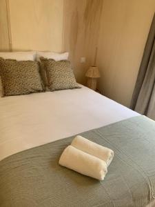 a white towel sitting on the end of a bed at La cabane in Beaurepaire