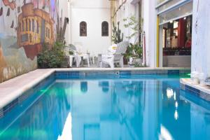 a swimming pool with blue water in a building at Hotel Ibiza in Villa Gesell