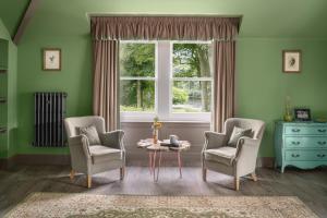 sala de estar con 2 sillas, mesa y ventana en Meikleour Arms Hotel & Restaurant, en Meikleour