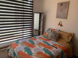 a bedroom with a bed and a window at Hermosa casa cerca de Aeropuerto in Quito
