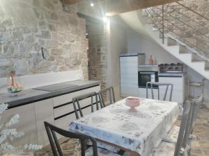 una cocina con una mesa con sillas y una escalera en Vecchio Casale Quercetino, en Montenero