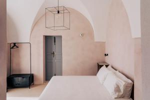 a bedroom with a white bed and a black table at Casale Madre in Ostuni +91 photos