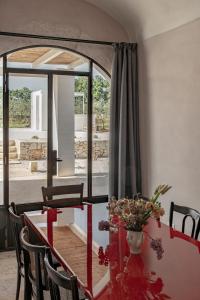 a dining room table with a vase of flowers on it at Casale Madre in Ostuni
