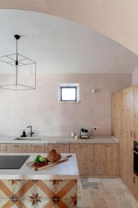 a kitchen with a sink and a counter with a table at Casale Madre in Ostuni